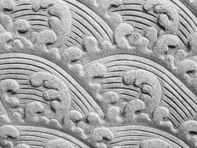 Detailed close-up of intricate stone carving on a mausoleum wall.